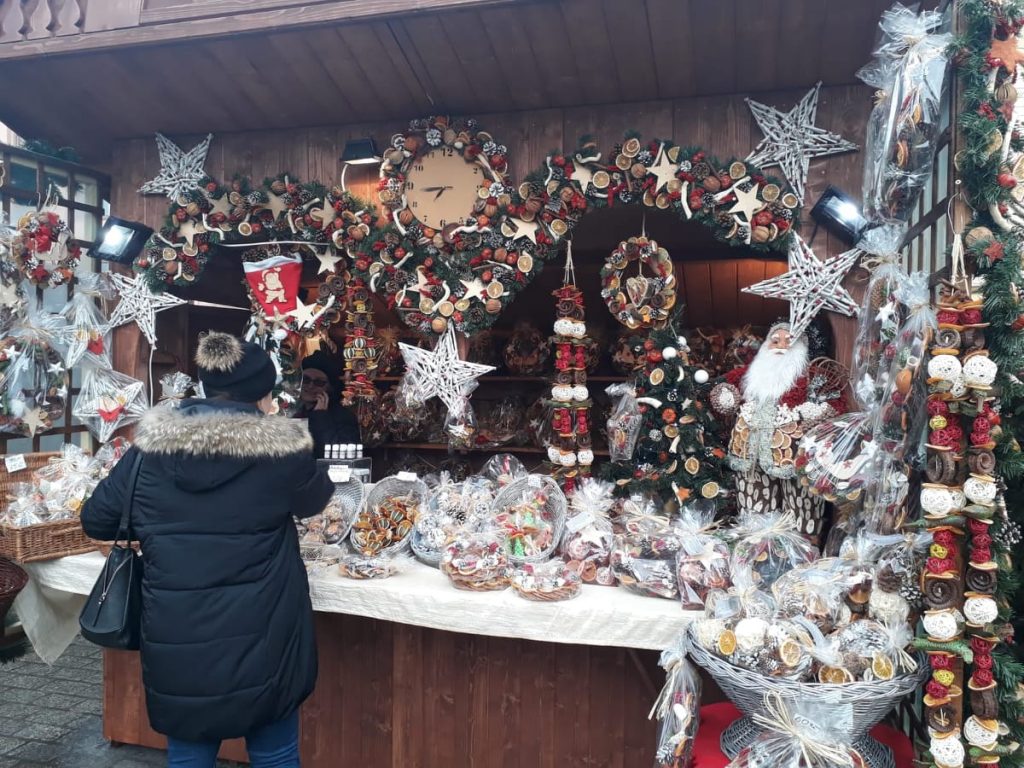 Puesto de artesanía local vendiendo adornos navideños hechos a mano en Cracovia