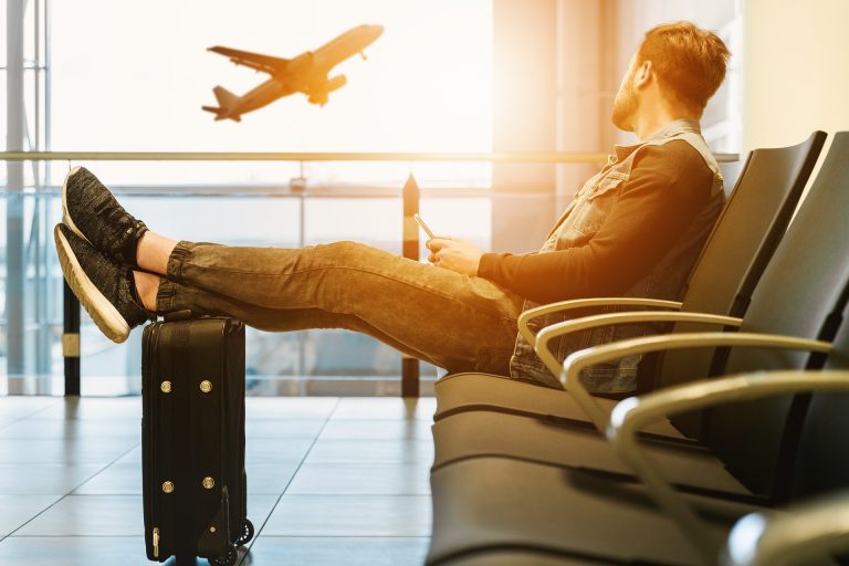 Pasajero esperando en el aeropuerto tras un vuelo retrasado, con derecho a solicitar indemnización