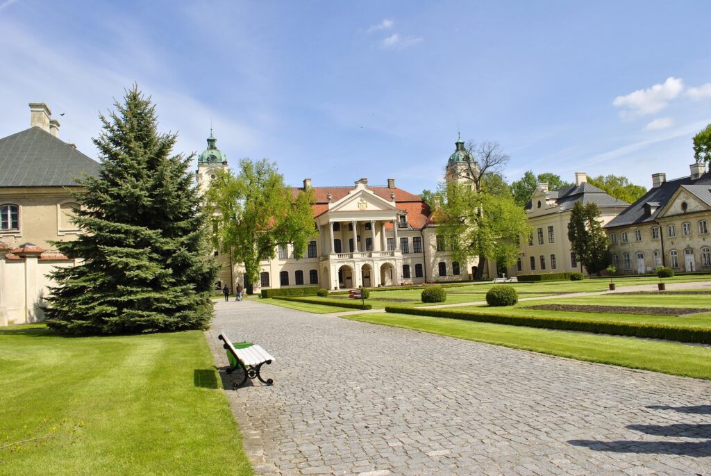 Fachada del palacio de Kozłówka rodeado de jardines y esculturas históricas