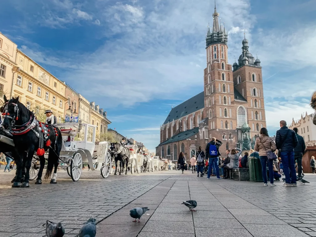 Basílica de Santa María y carruajes de caballos en la Plaza del Mercado de Cracovia, Polonia