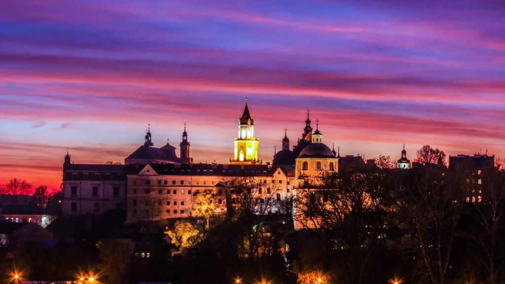 Panorámica del casco antiguo de Lublin iluminado al atardecer bajo un cielo rosado