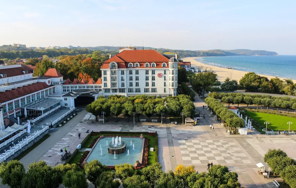 Paseo marítimo de Sopot con jardines, un hotel y la playa del mar Báltico