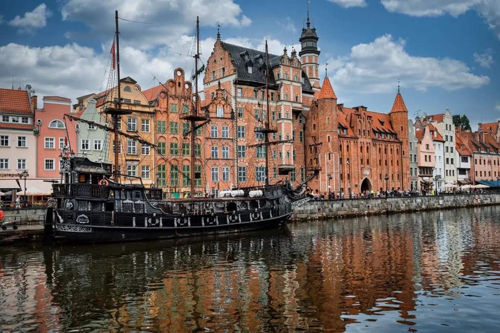 Barco pirata turístico frente a edificios históricos del casco antiguo de Gdansk, junto al río Motława